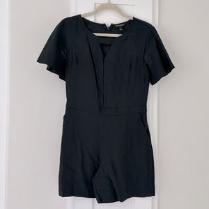 Black romper with cut out detail. Zipper back. Fits like a small